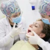 Doctoras preparando la infiltración de anestesia dental en el área peribucal de una paciente en la clínica..