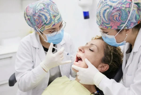 Doctoras preparando la infiltración de anestesia dental en el área peribucal de una paciente en la clínica..
